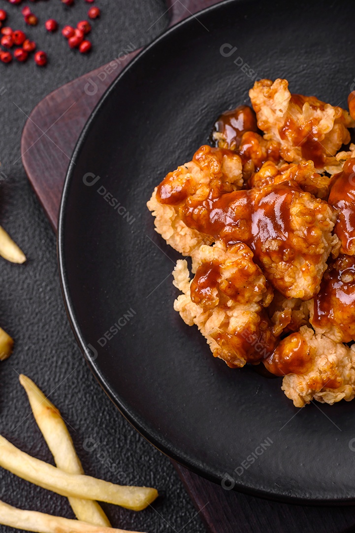 Deliciosas mordidas suculentas de carne de frango grelhado com sal, especiarias e ervas em um fundo escuro de concreto