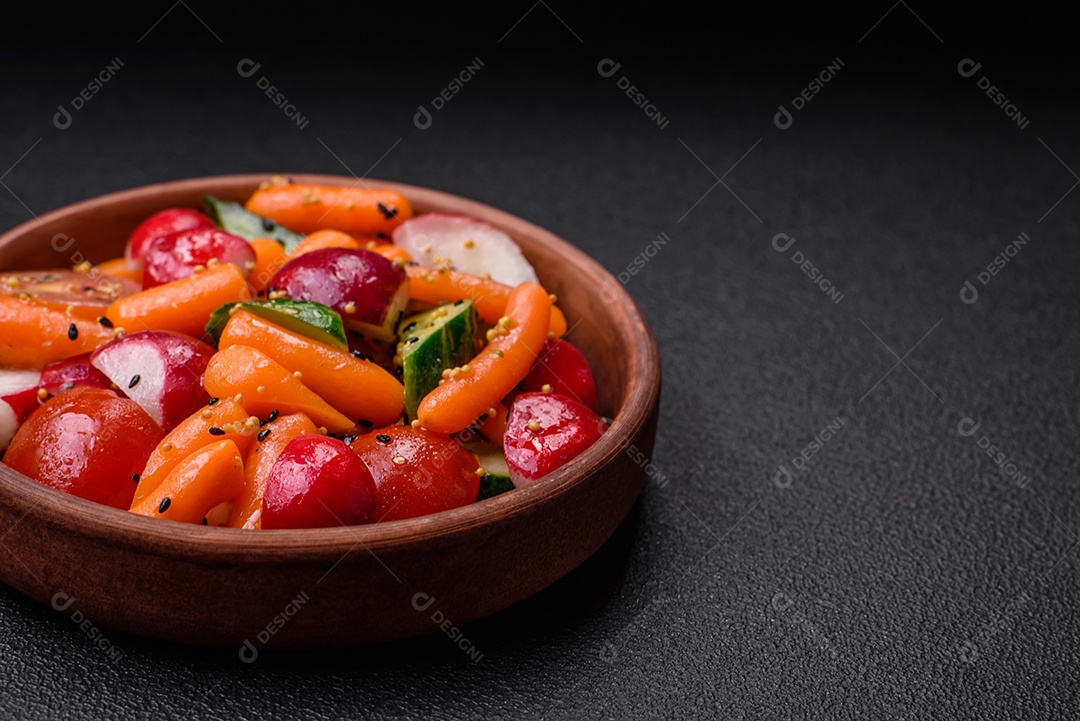 Deliciosa salada fresca e suculenta com rabanetes, tomates, cenouras, pepino, especiarias e ervas sobre um fundo escuro de concreto