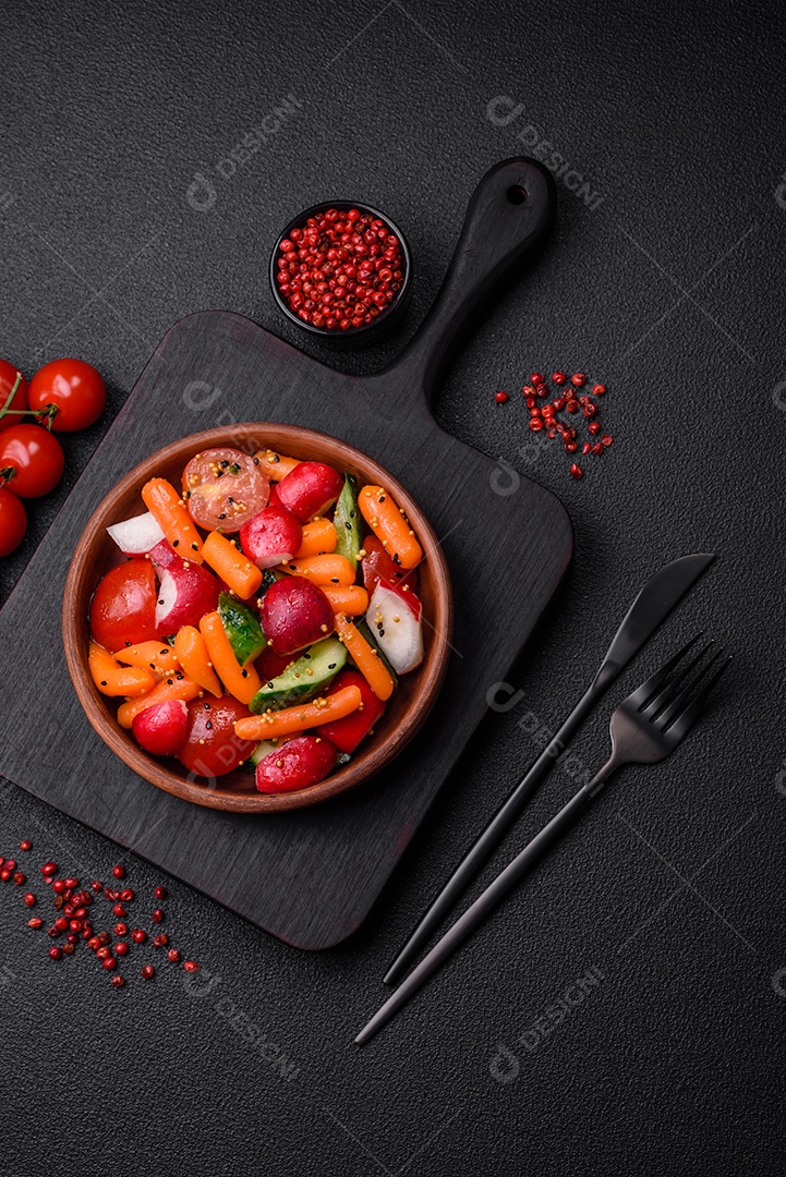 Deliciosa salada fresca e suculenta com rabanetes, tomates, cenouras, pepino, especiarias e ervas sobre um fundo escuro de concreto