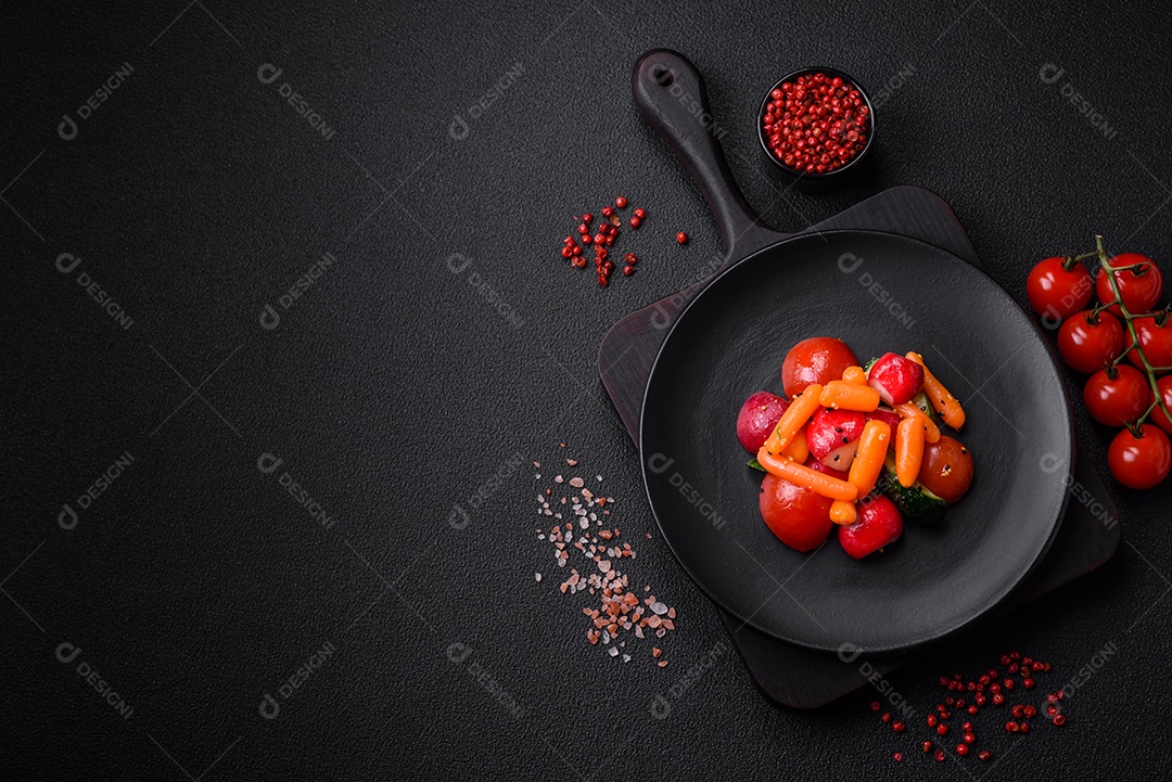 Deliciosa salada fresca e suculenta com rabanetes, tomates, cenouras, pepino, especiarias e ervas sobre um fundo escuro de concreto