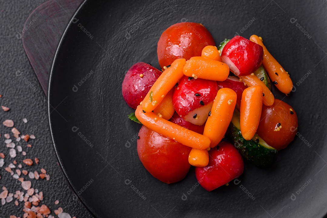 Deliciosa salada fresca e suculenta com rabanetes, tomates, cenouras, pepino, especiarias e ervas sobre um fundo escuro de concret