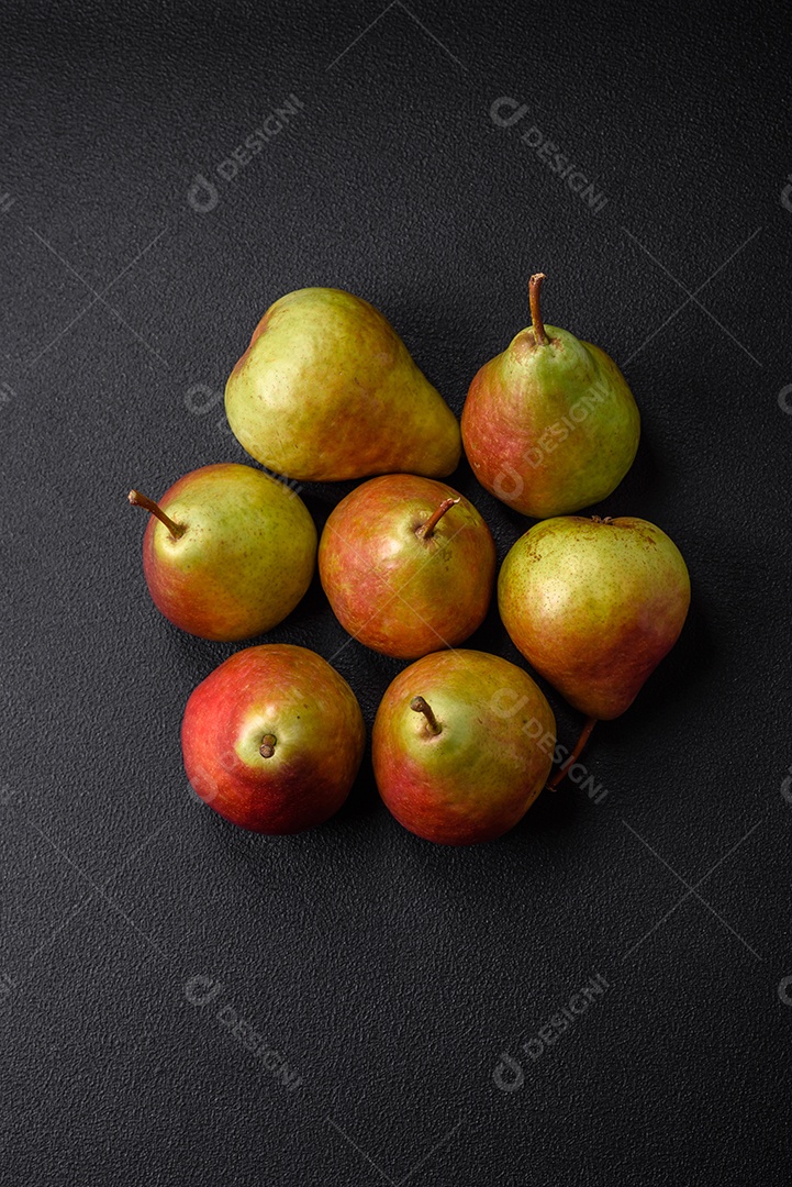 Deliciosa pera verde doce e suculenta com lado vermelho em fundo de concreto texturizado escuro