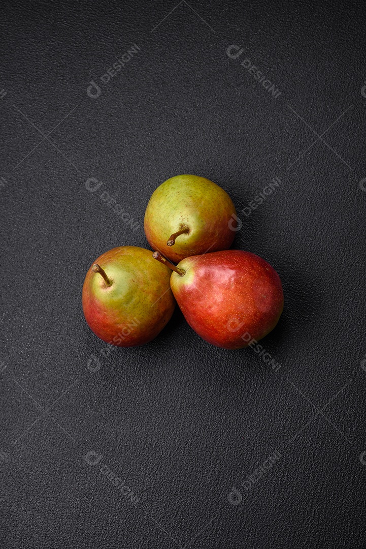 Deliciosa pera verde doce e suculenta com lado vermelho em fundo de concreto texturizado escuro