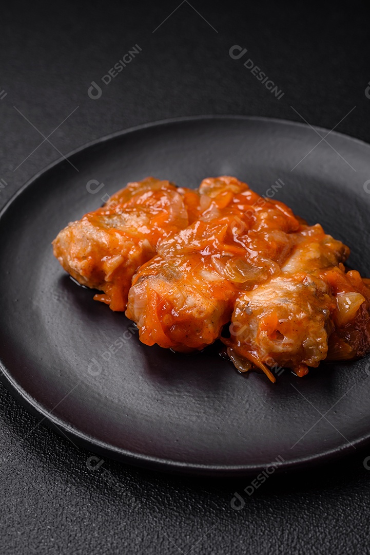 Delicioso guisado fresco de batatas, tomates, cebolas, cenouras e carne bovina com sal, especiarias e ervas sobre um fundo escuro de concreto