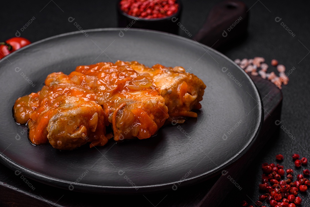 Delicioso guisado fresco de batatas, tomates, cebolas, cenouras e carne bovina com sal, especiarias e ervas sobre um fundo escuro de concreto