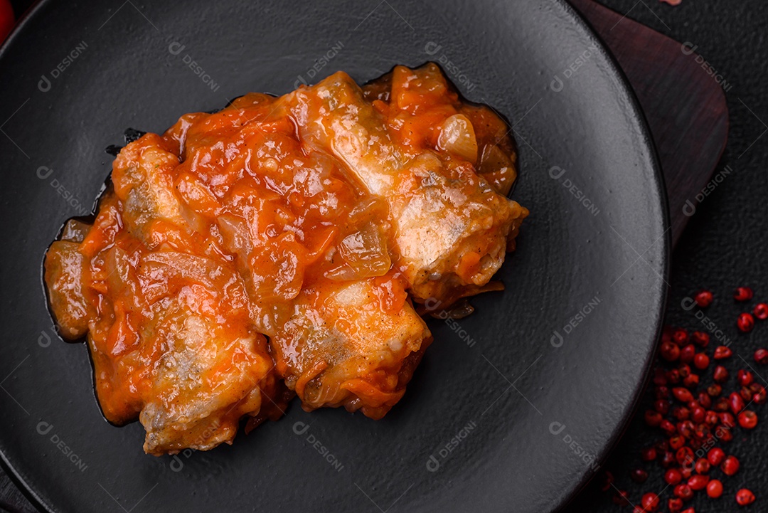 Delicioso guisado fresco de batatas, tomates, cebolas, cenouras e carne bovina com sal, especiarias e ervas sobre um fundo escuro de concreto