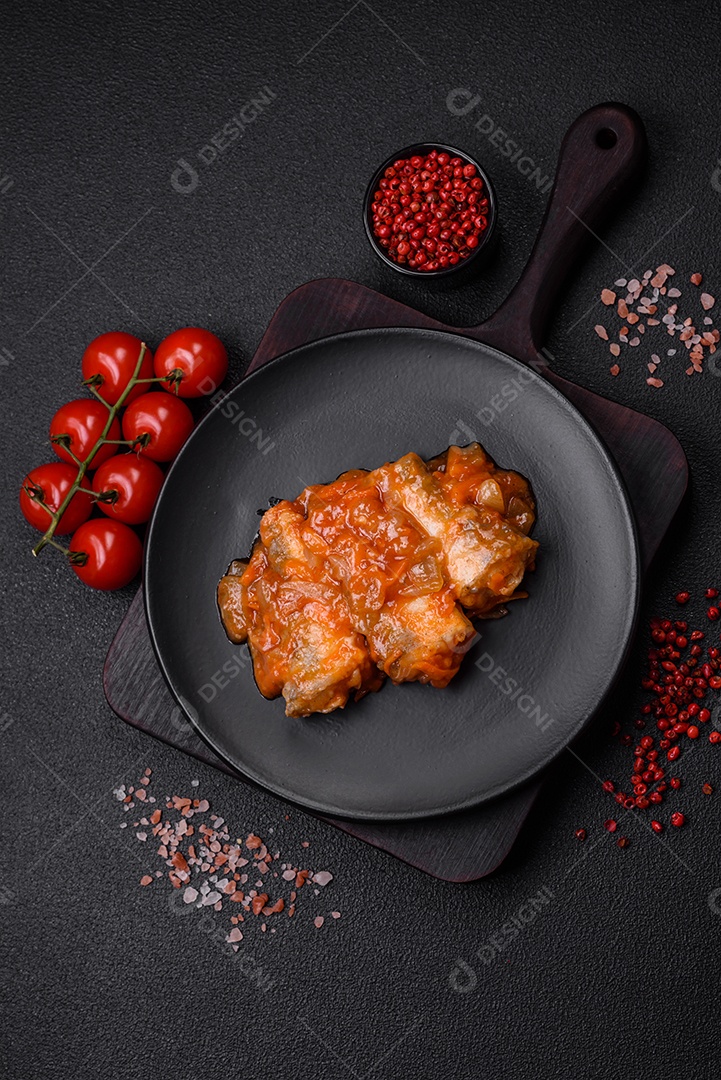 Delicioso guisado fresco de batatas, tomates, cebolas, cenouras e carne bovina com sal, especiarias e ervas sobre um fundo escuro de concreto