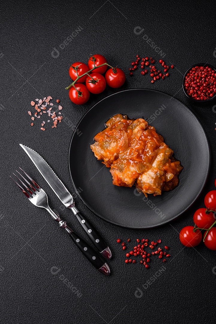 Delicioso macarrão asiático fresco com pedaços de legumes, carne, com sal, especiarias e ervas sobre um fundo escuro de concreto
