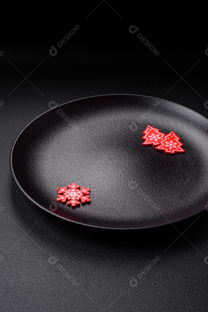 Placa preta cerâmica vazia com elementos de decoração de Natal em fundo de concreto texturizado de férias