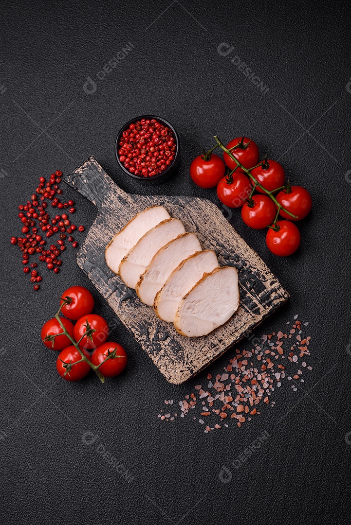 Delicioso suculento filé de frango grelhado com sal, especiarias e ervas sobre um fundo escuro de concreto
