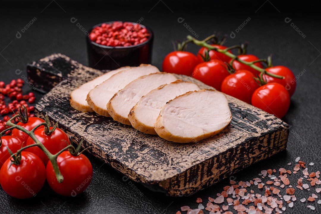 Delicioso suculento filé de frango grelhado com sal, especiarias e ervas sobre um fundo escuro de concreto