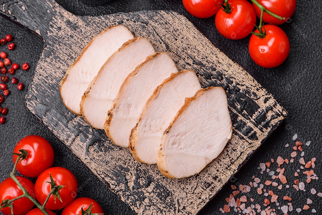 Delicioso suculento filé de frango grelhado com sal, especiarias e ervas sobre um fundo escuro de concreto