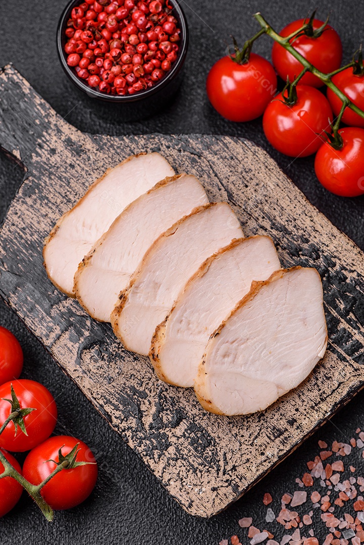 Delicioso suculento filé de frango grelhado com sal, especiarias e ervas sobre um fundo escuro de concreto