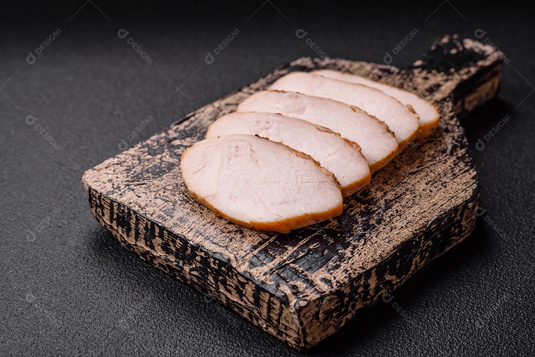 Delicioso suculento filé de frango grelhado com sal, especiarias e ervas sobre um fundo escuro de concreto