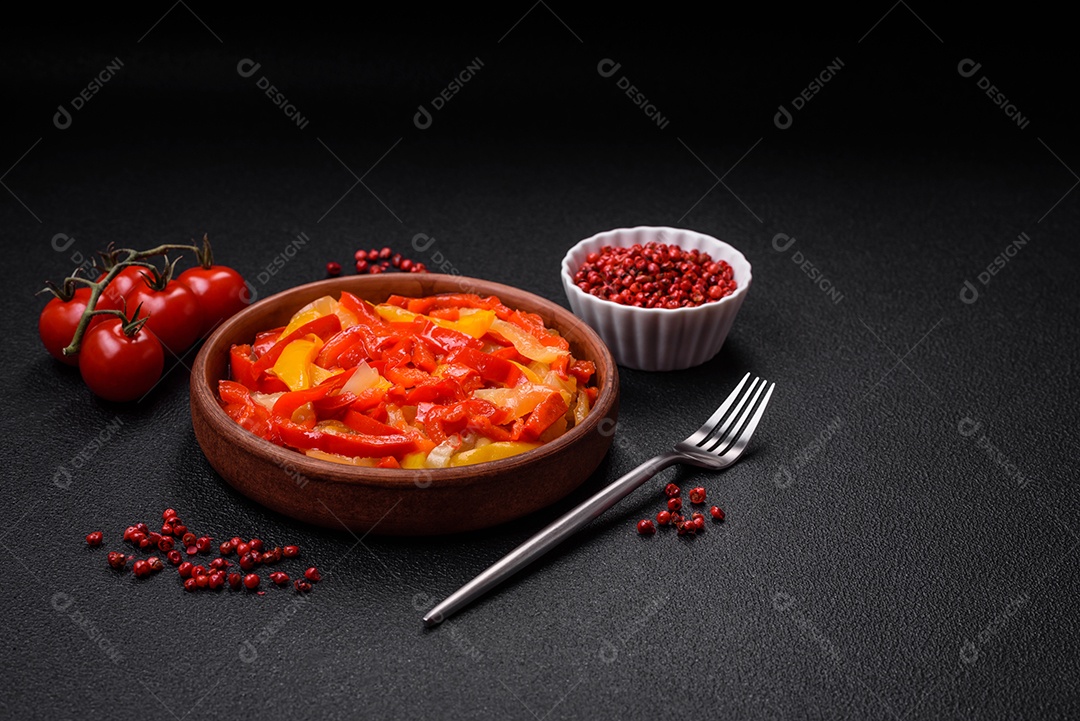 Deliciosas fatias frescas de pimentão doce com cebola, sal, especiarias e ervas sobre um fundo escuro de concreto