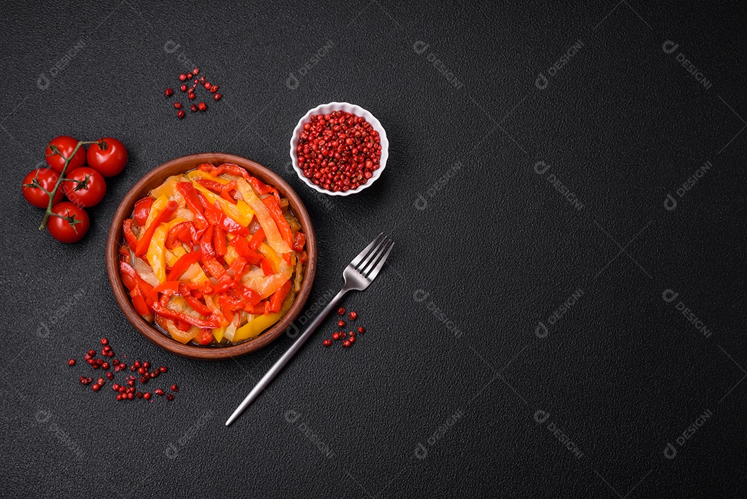 Deliciosas fatias frescas de pimentão doce com cebola, sal, especiarias e ervas sobre um fundo escuro de concreto