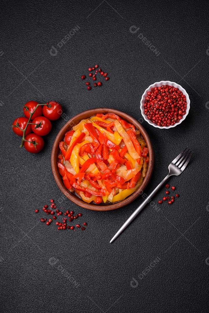 Deliciosas fatias frescas de pimentão doce com cebola, sal, especiarias e ervas sobre um fundo escuro de concreto