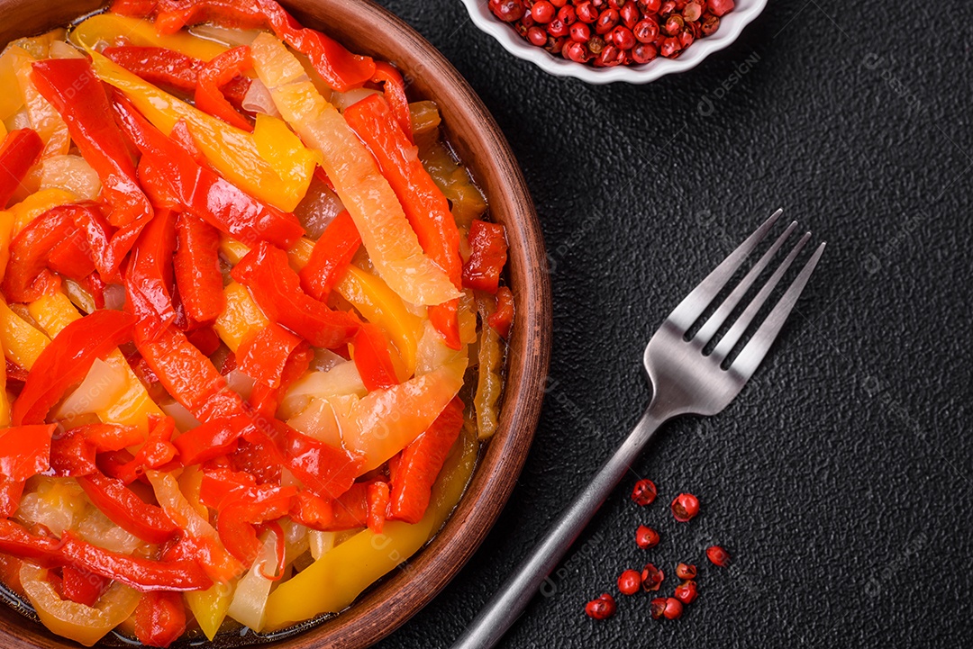 Deliciosas fatias frescas de pimentão doce com cebola, sal, especiarias e ervas sobre um fundo escuro de concreto