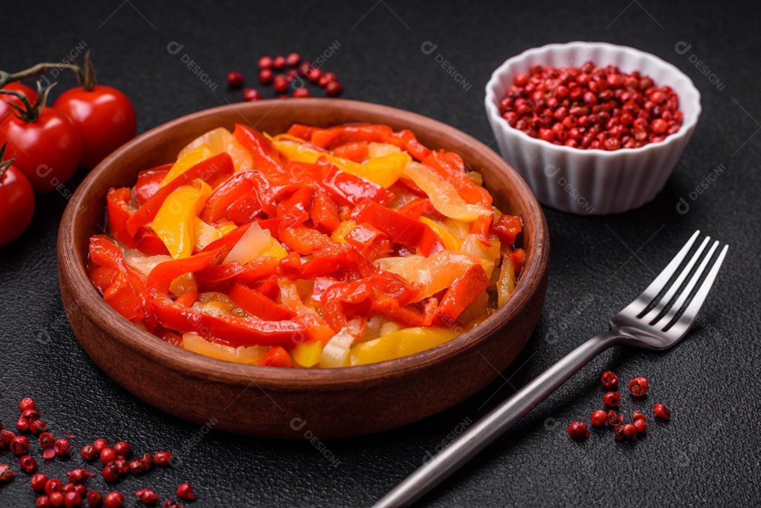 Deliciosas fatias frescas de pimentão doce com cebola, sal, especiarias e ervas sobre um fundo escuro de concreto