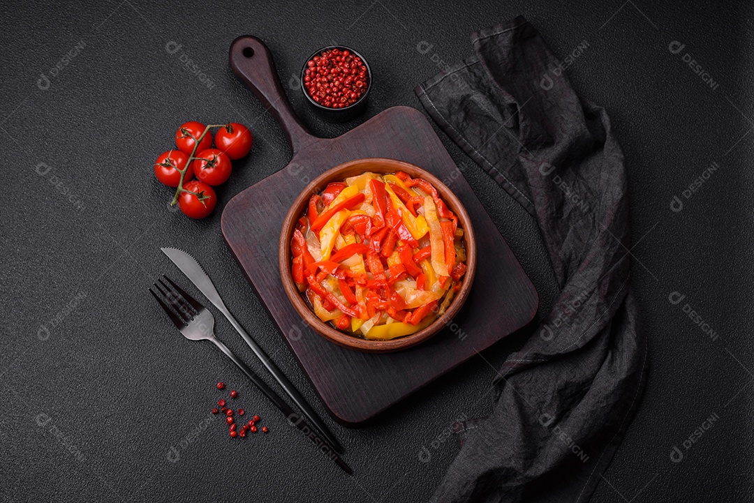 Deliciosas fatias frescas de pimentão doce com cebola, sal, especiarias e ervas sobre um fundo escuro de concreto