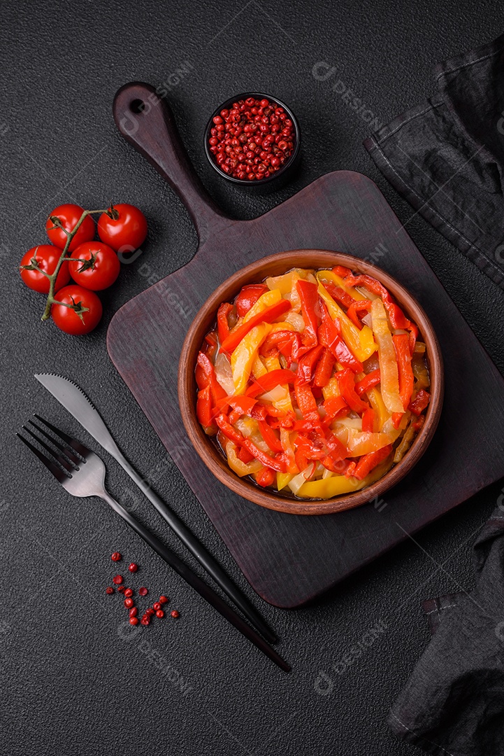 Deliciosas fatias frescas de pimentão doce com cebola, sal, especiarias e ervas sobre um fundo escuro de concreto