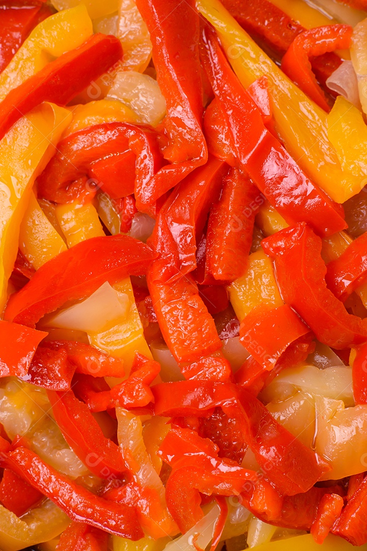 Deliciosas fatias frescas de pimentão doce com cebola, sal, especiarias e ervas sobre um fundo escuro de concreto