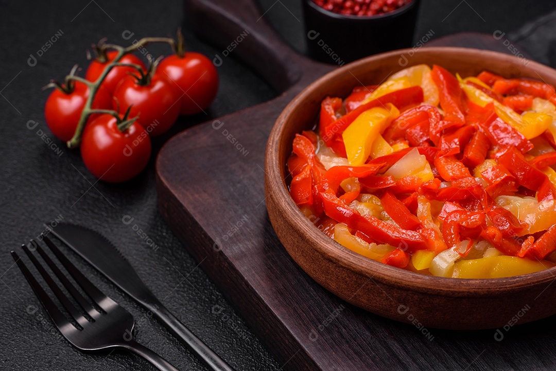 Deliciosas fatias frescas de pimentão doce com cebola, sal, especiarias e ervas sobre um fundo escuro de concreto