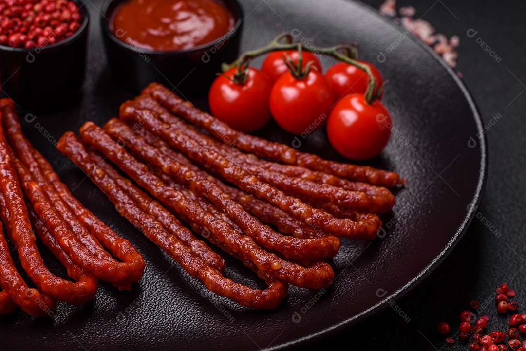 Deliciosas salsichas de caça defumadas com sal, especiarias e ervas sobre um fundo escuro de concreto