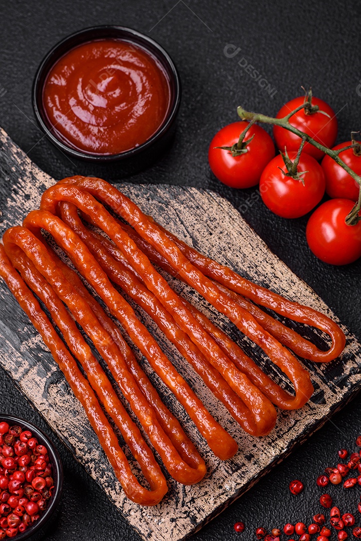 Deliciosas salsichas de caça defumadas com sal, especiarias e ervas sobre um fundo escuro de concreto