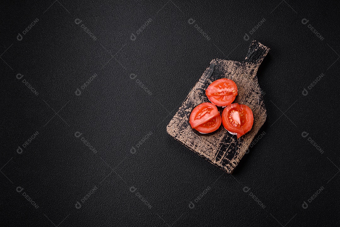 Deliciosa berinjela cortada em círculos grelhada e cozida com maionese e tomate em fundo escuro de concreto