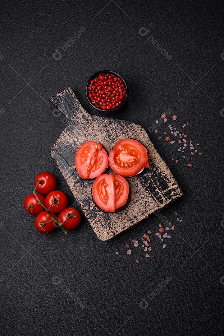 Deliciosa berinjela cortada em círculos grelhada e cozida com maionese e tomate em fundo escuro de concreto