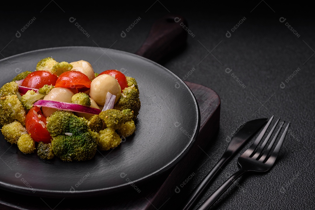 Deliciosa salada fresca de feijão verde, ervilha, pimentão e queijo com sal e especiarias sobre um fundo escuro de concreto