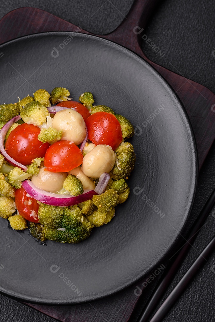 Deliciosa salada fresca de feijão verde, ervilha, pimentão e queijo com sal e especiarias sobre um fundo escuro de concreto
