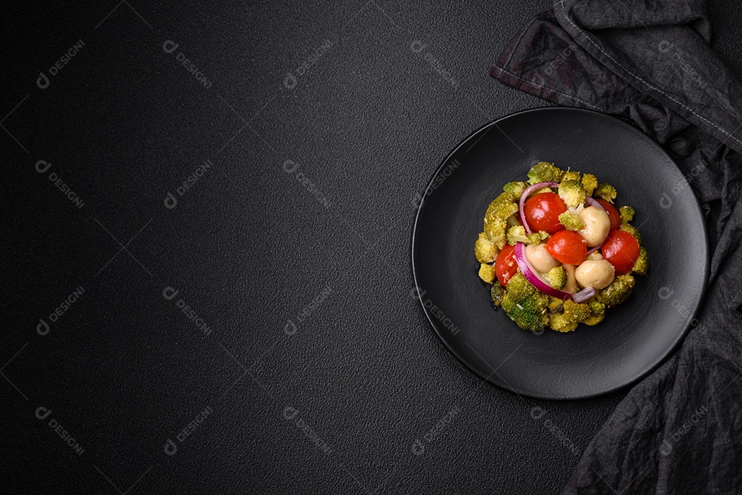 Deliciosa salada fresca de feijão verde, ervilha, pimentão e queijo com sal e especiarias sobre um fundo escuro de concreto