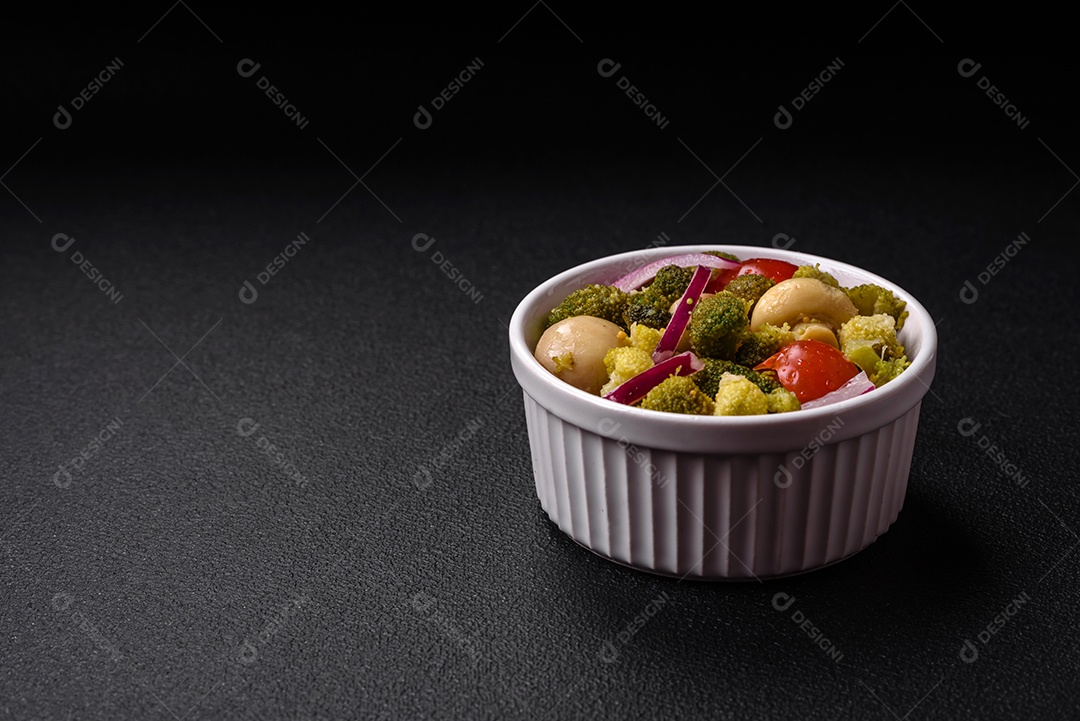 Deliciosa salada fresca de feijão verde, ervilha, pimentão e queijo com sal e especiarias sobre um fundo escuro de concreto