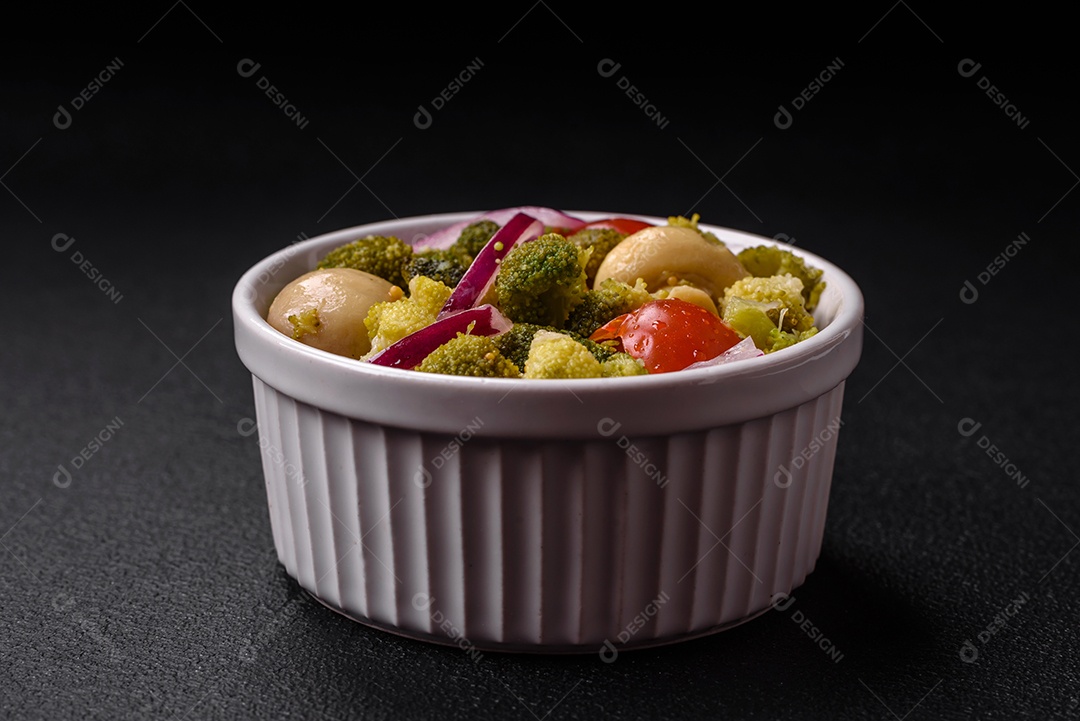 Deliciosa salada fresca de feijão verde, ervilha, pimentão e queijo com sal e especiarias sobre um fundo escuro de concreto