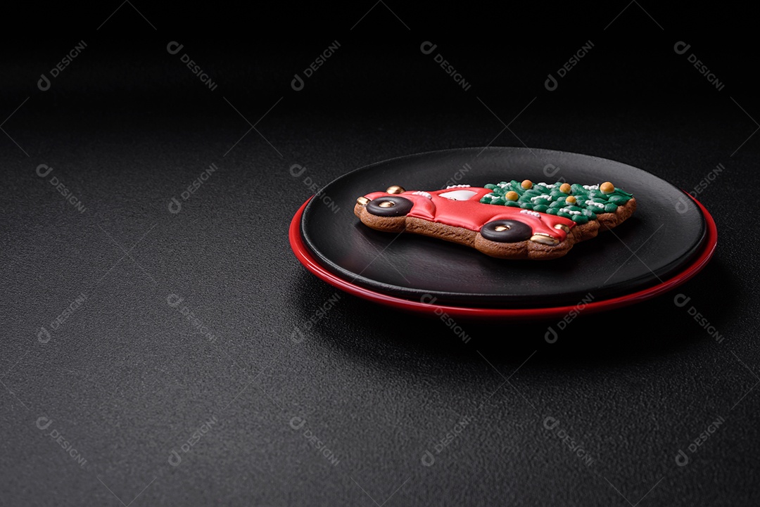 Uma bela composição de Natal composta por pratos de cerâmica, pão de gengibre e outros elementos de decoração de Ano Novo sobre um fundo escuro de concreto