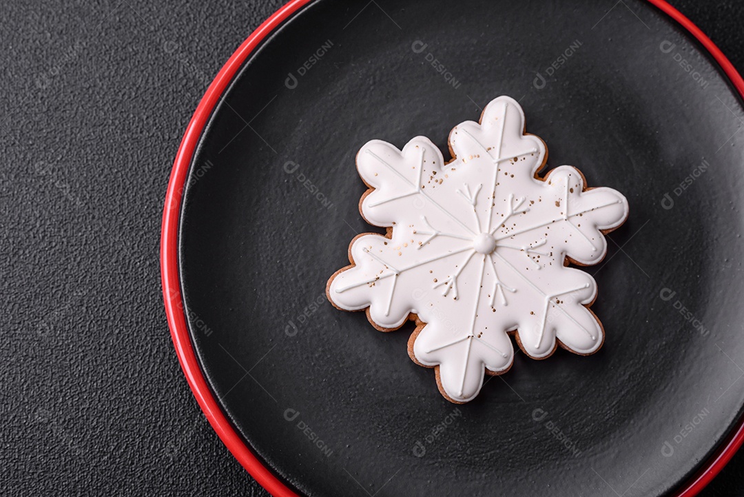 Uma bela composição de Natal composta por pratos de cerâmica, pão de gengibre e outros elementos de decoração de Ano Novo sobre um fundo escuro de concreto