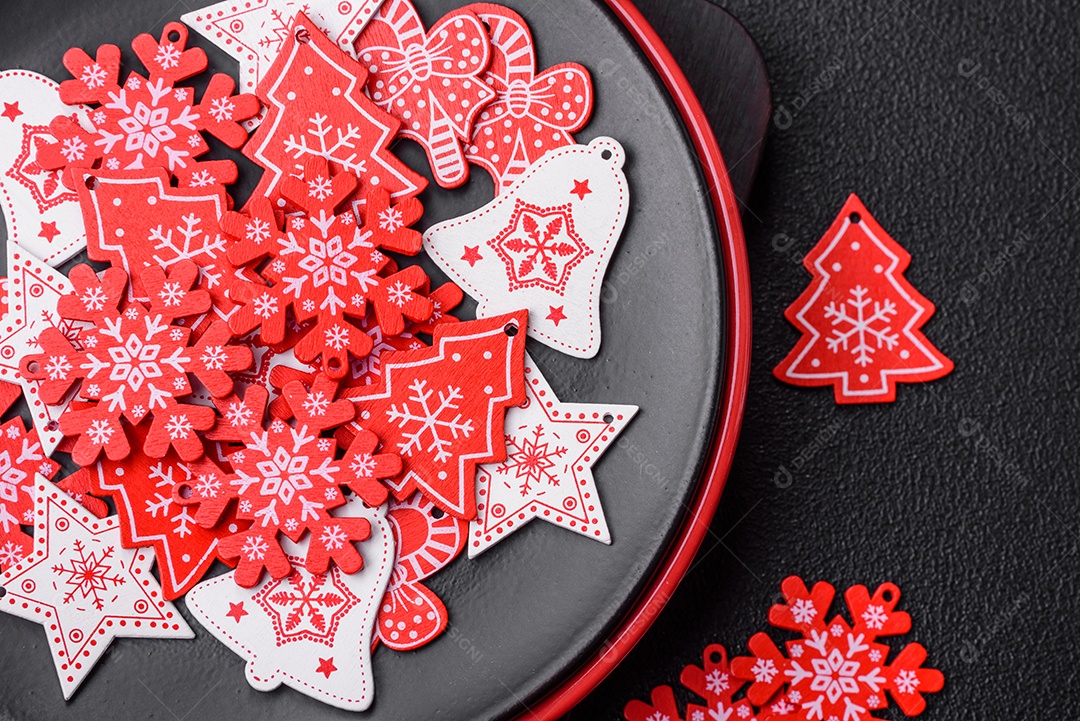 Uma bela composição de Natal composta por pratos de cerâmica, pão de gengibre e outros elementos de decoração de Ano Novo sobre um fundo escuro de concreto