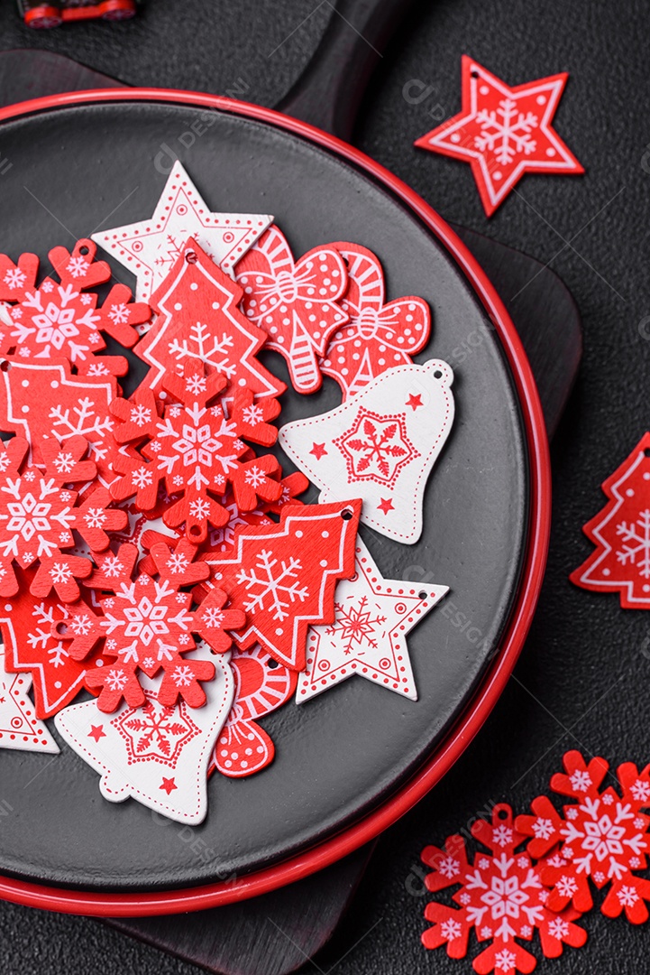 Uma bela composição de Natal composta por pratos de cerâmica, pão de gengibre e outros elementos de decoração de Ano Novo sobre um fundo escuro de concreto