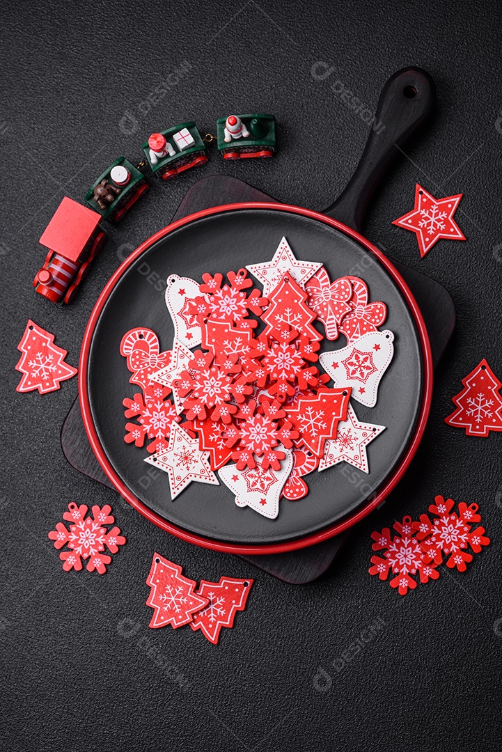 Uma bela composição de Natal composta por pratos de cerâmica, pão de gengibre e outros elementos de decoração de Ano Novo sobre um fundo escuro de concreto