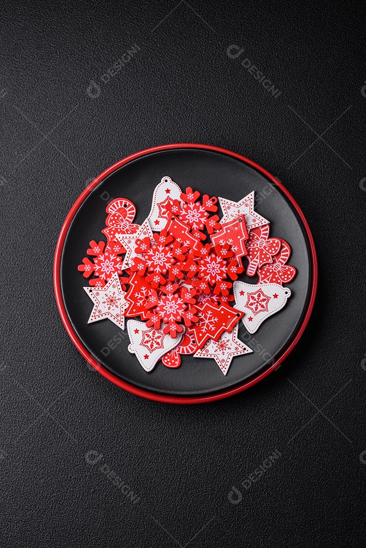 Uma bela composição de Natal composta por pratos de cerâmica, pão de gengibre e outros elementos de decoração de Ano Novo sobre um fundo escuro de concreto