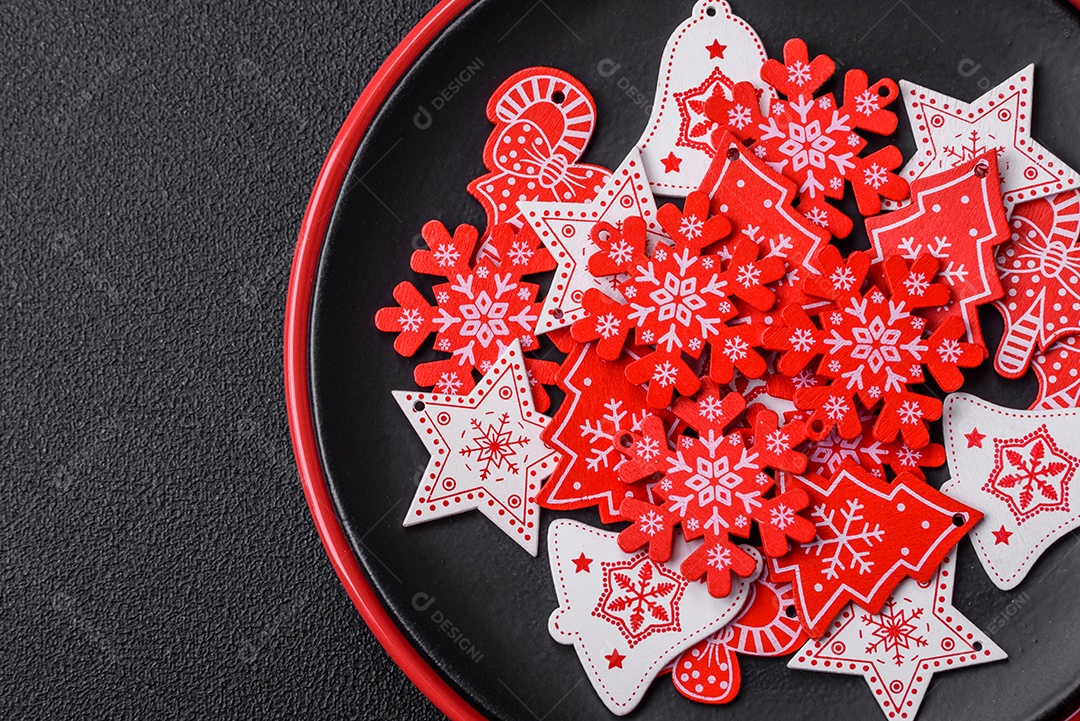 Uma bela composição de Natal composta por pratos de cerâmica, pão de gengibre e outros elementos de decoração de Ano Novo sobre um fundo escuro de concreto