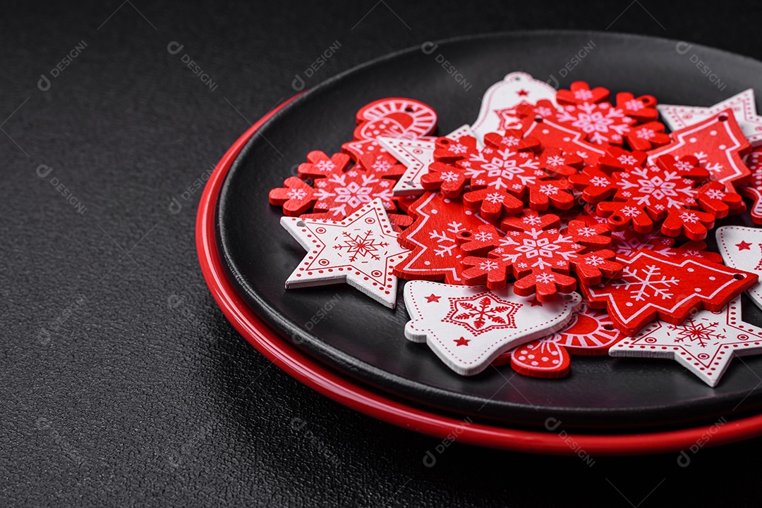 Uma bela composição de Natal composta por pratos de cerâmica, pão de gengibre e outros elementos de decoração de Ano Novo sobre um fundo escuro de concreto