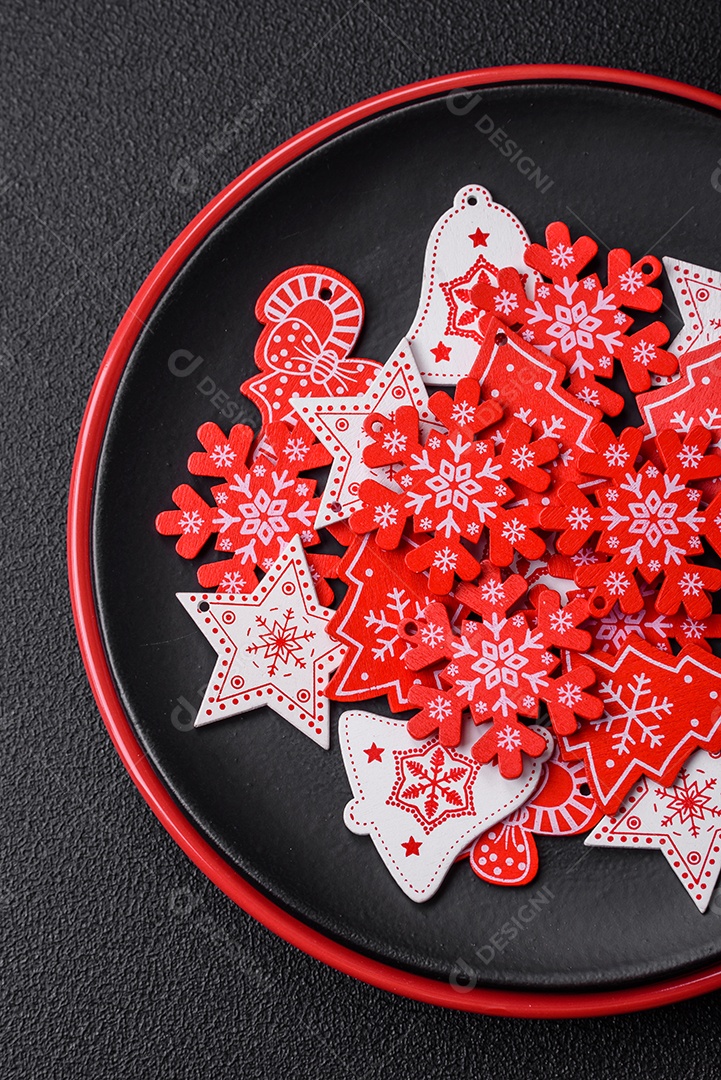 Uma bela composição de Natal composta por pratos de cerâmica, pão de gengibre e outros elementos de decoração de Ano Novo sobre um fundo escuro de concreto