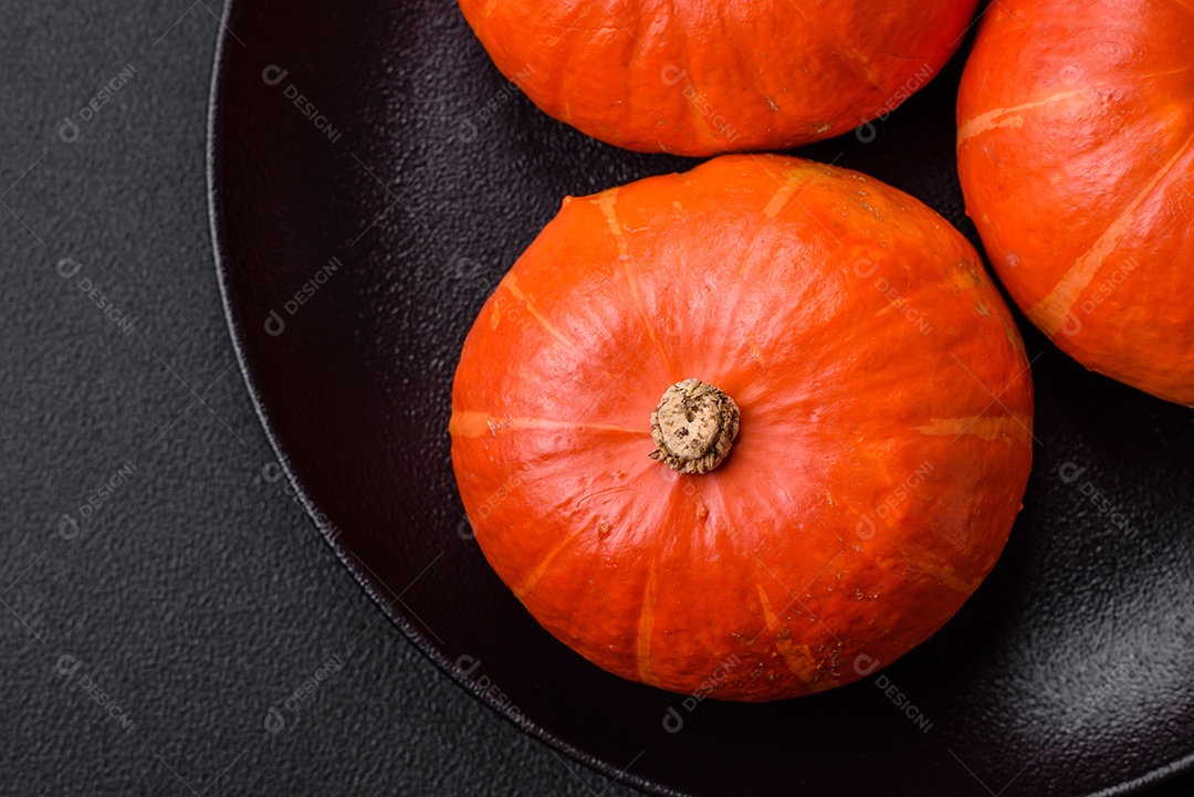 Lindas abóboras redondas frescas na cor laranja sobre um fundo escuro de concreto. Preparando-se para a celebração do Halloween