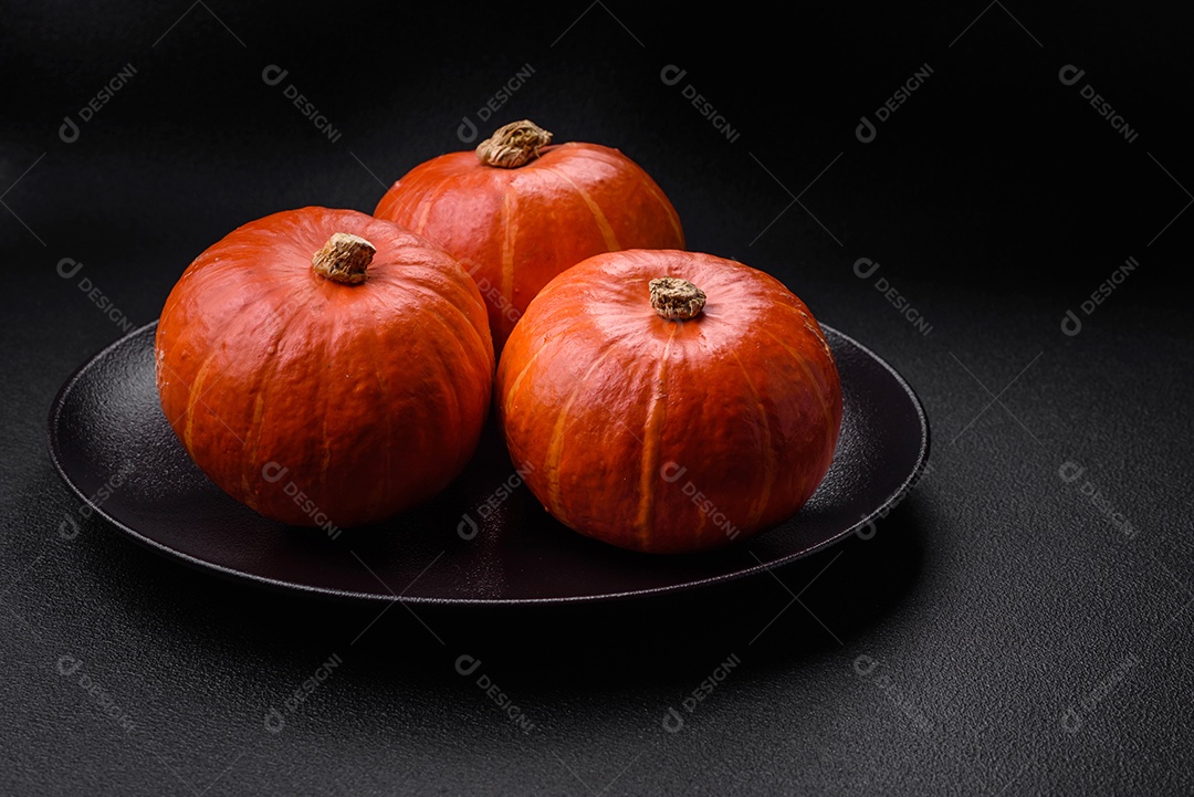 Lindas abóboras redondas frescas na cor laranja sobre um fundo escuro de concreto. Preparando-se para a celebração do Halloween