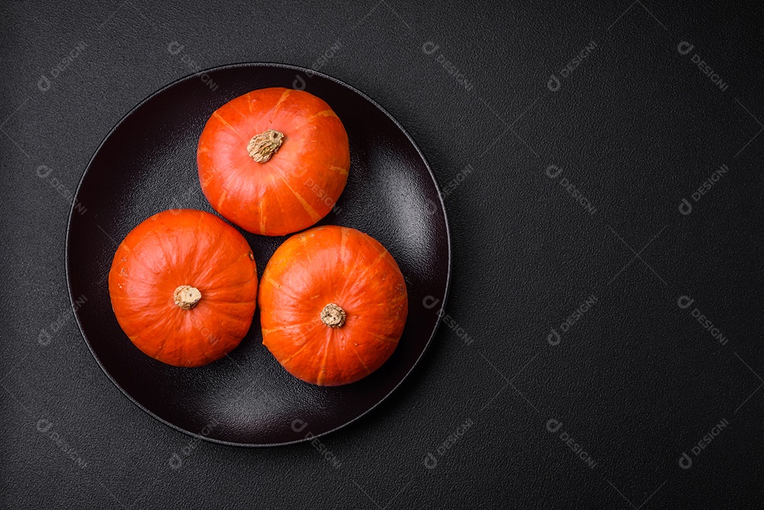 Lindas abóboras redondas frescas na cor laranja sobre um fundo escuro de concreto. Preparando-se para a celebração do Halloween