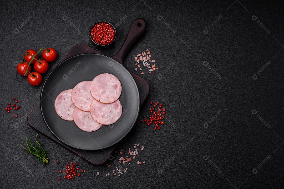 Delicioso presunto fresco cortado em fatias redondas com sal, especiarias e ervas sobre fundo escuro de concreto