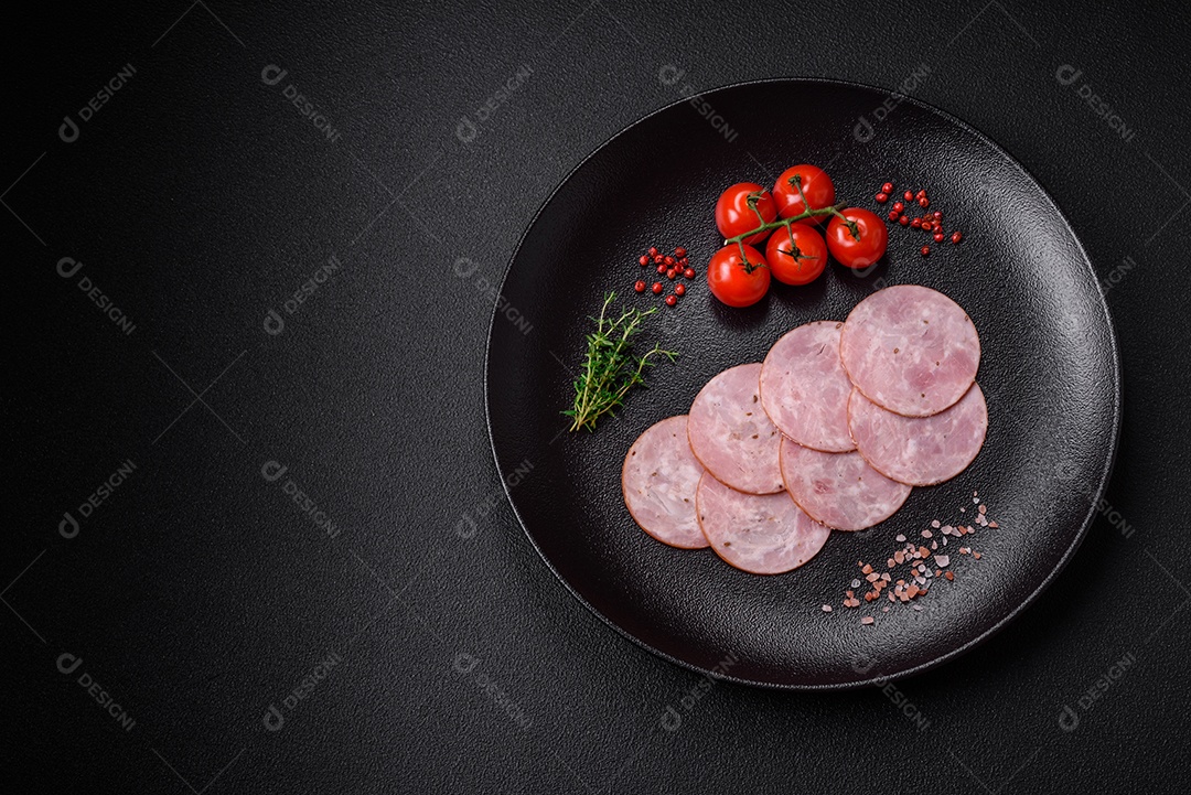 Delicioso presunto fresco cortado em fatias redondas com sal, especiarias e ervas sobre fundo escuro de concreto